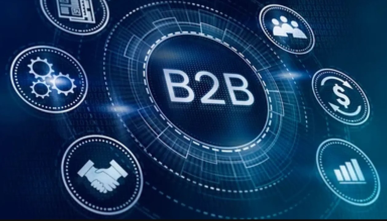 A futuristic blue digital interface with a central circle displaying "B2B" text, surrounded by interconnected icons representing handshake, growth graph, dollar transaction, team, and gears.